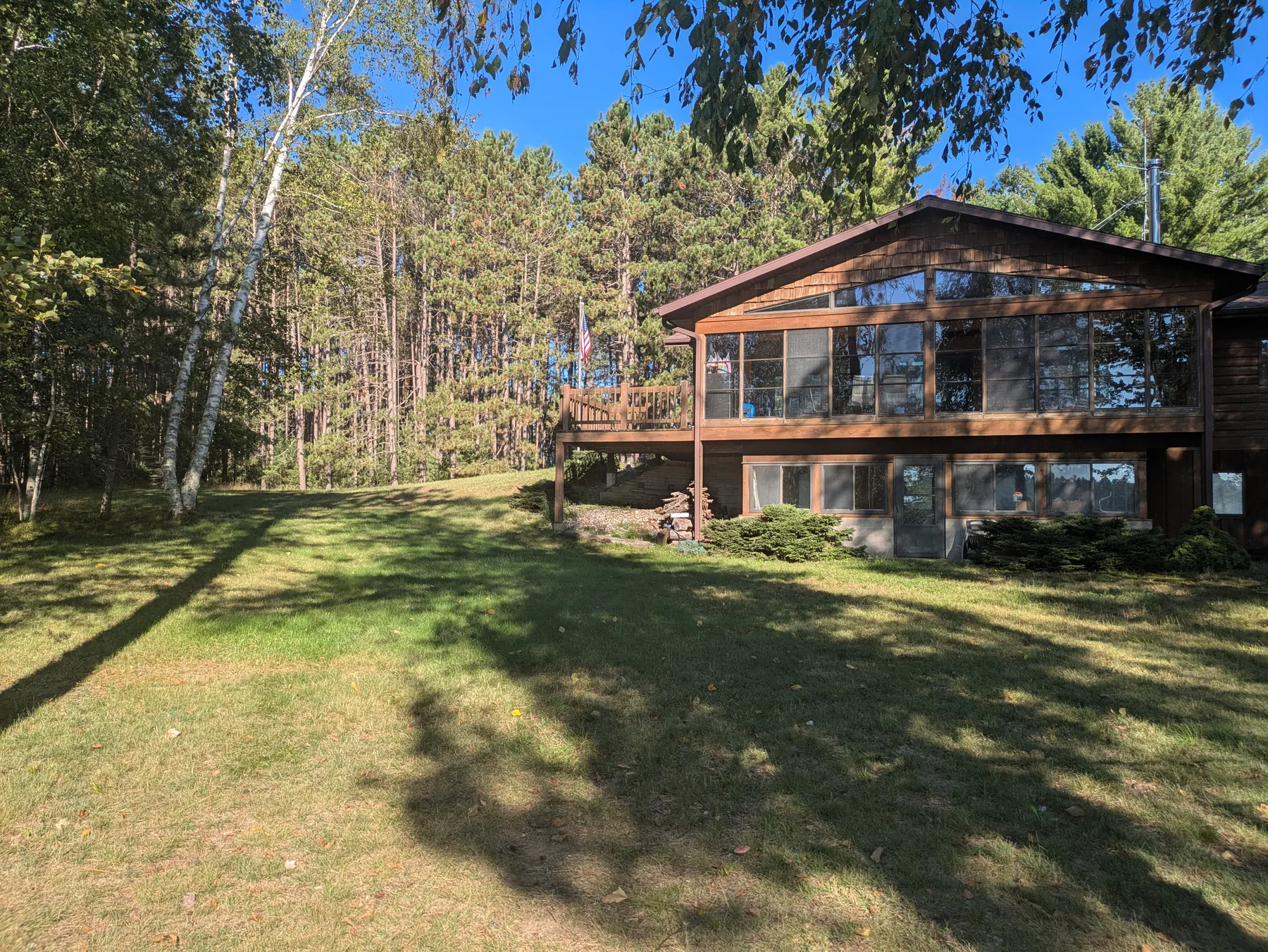 Lakeside elevation of the house and sunroom seen across the lawn