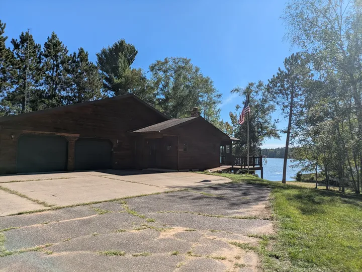 Driveway approaching the house and attached garage with the lake beyond