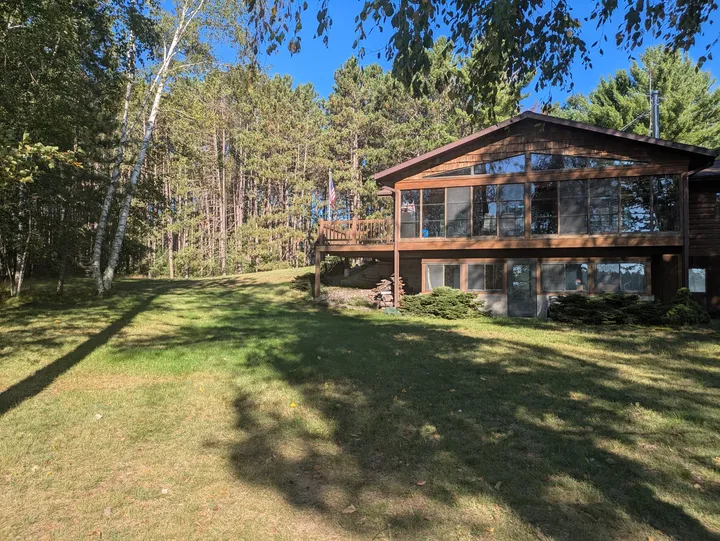 Lakeside elevation of the house and sunroom seen across the lawn
