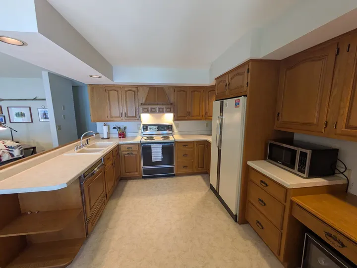 Kitchen workspace with wood cabinets, range and refrigerator