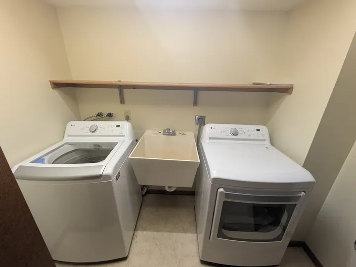 Main-level laundry area with a washer, utility sink and dryer