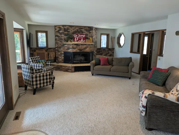 Living room with lake-facing windows, seating and a brick fireplace