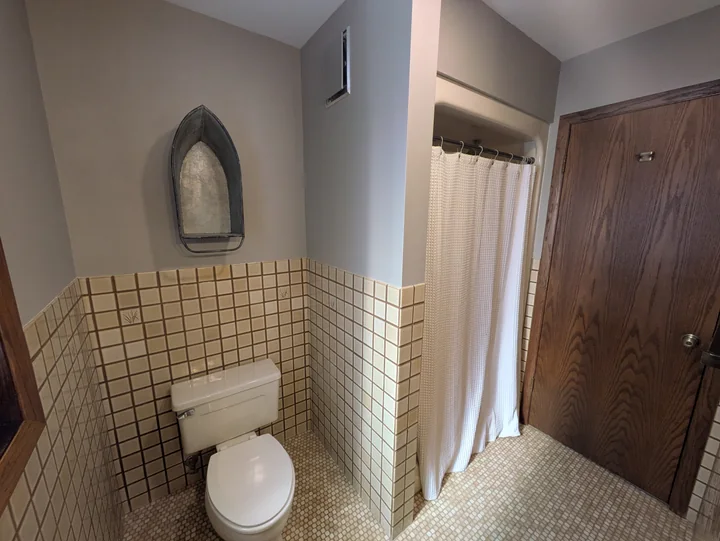 En-suite bathroom adjoining the primary bedroom, showing the shower, toilet and tiled walls
